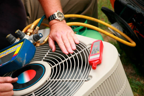 Technician servicing a residential outdoor air-conditioning condenser