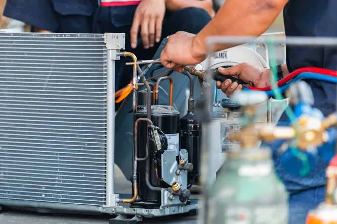 HVAC technicians diagnosing a residential outdoor air-conditioning system