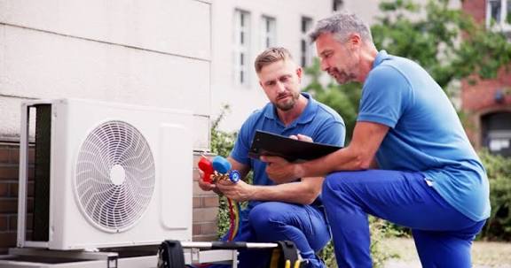HVAC professionals reviewing outdoor home comfort equipment