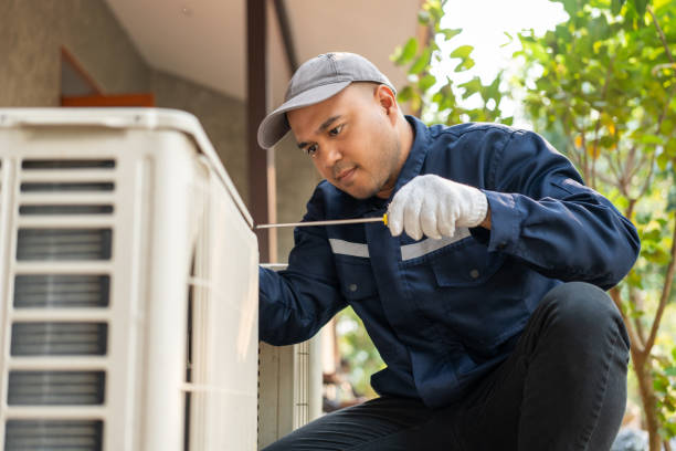 HVAC technician inspecting a residential outdoor cooling unit