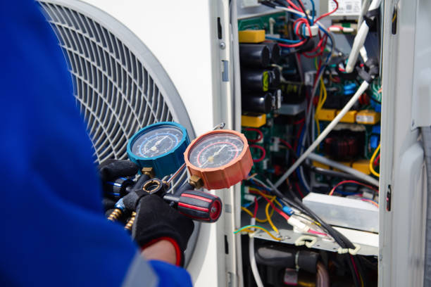 HVAC technician measuring a residential air-conditioning system with service gauges