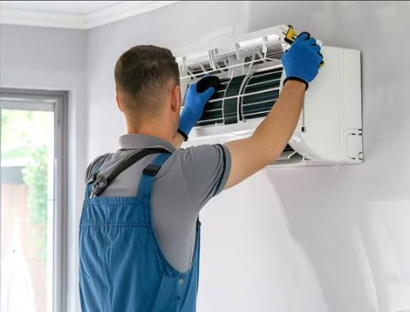 HVAC professional cleaning a wall-mounted home air-conditioning unit